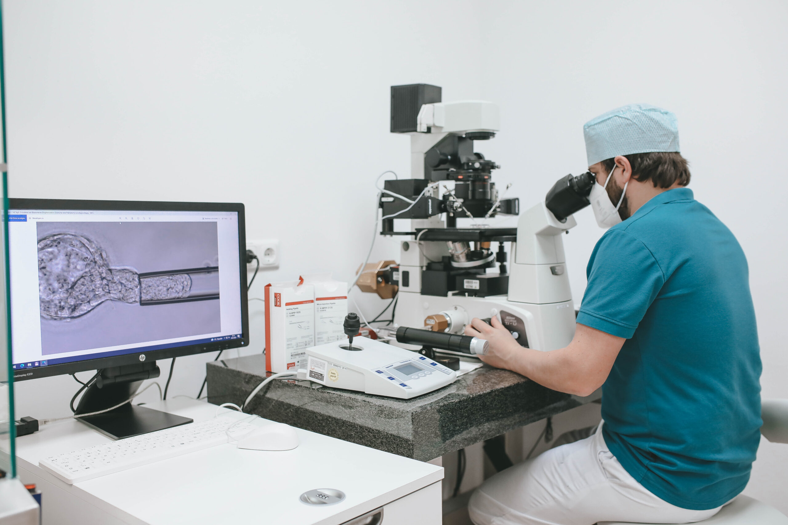 Kinderwunschklinik Labor Teammitglied Andreas Jungwirth am Mikroskop im IVF Labor während der Vorbereitung einer Präimplantationsdiagnostik