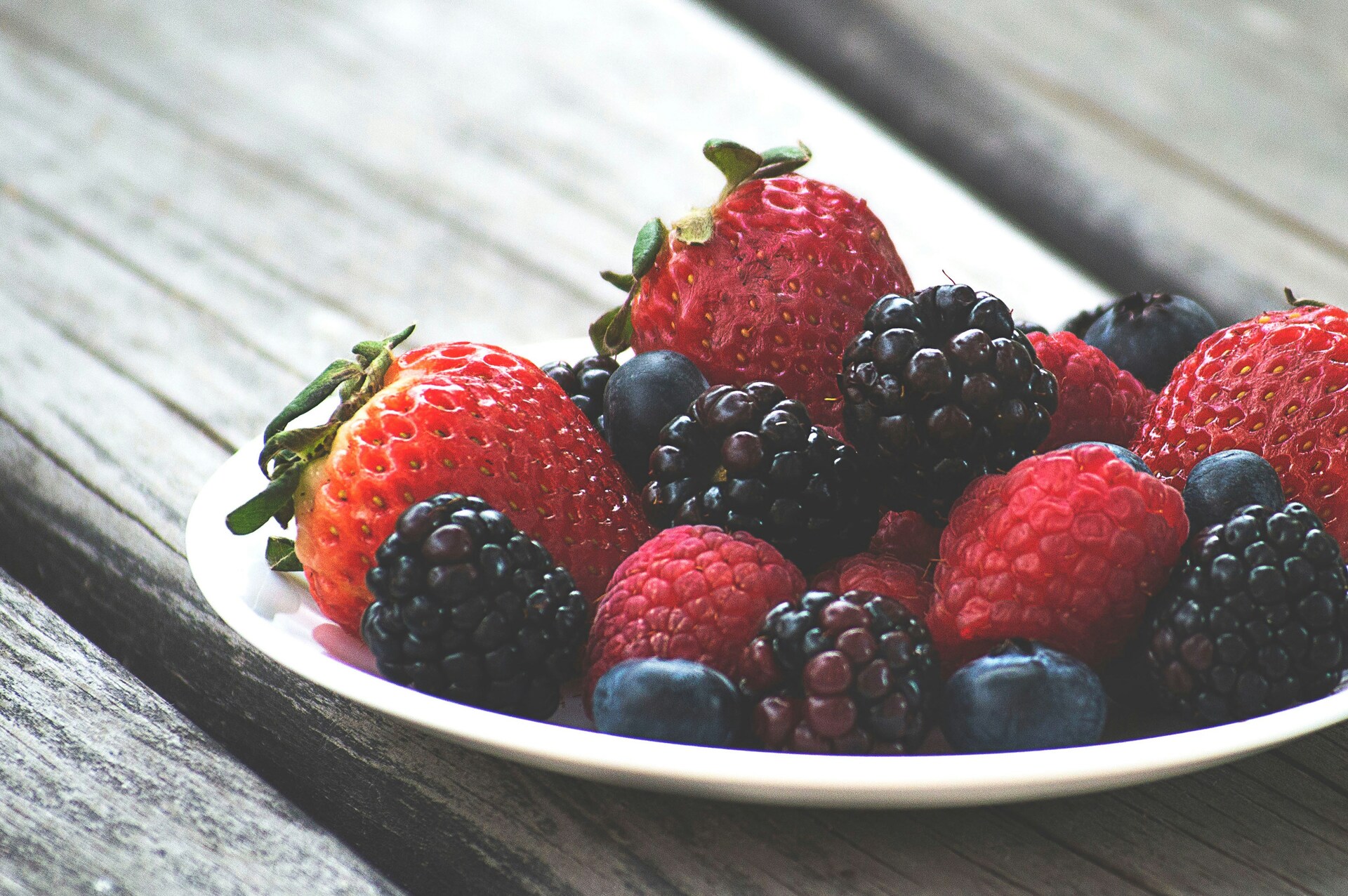 Erdbeeren, Himbeeren, Heidelbeeren, Brombeeren in einem Schälchen